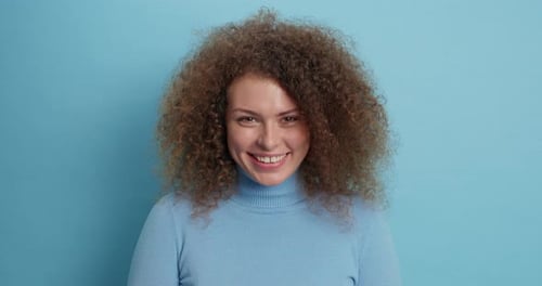 Smiling Woman With Curly Hair Posing in Studio