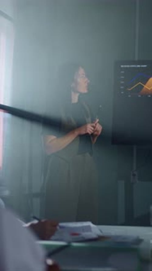 Business Professional Presenting Data Visualization on Digital Screen in Misty Conference Room with
