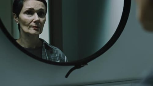 Woman Looks at Reflection in Mirror at Home