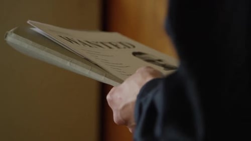 Police officer holding wanted poster in precinct HD