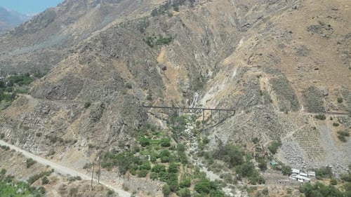 Aerial dolly shot in the mountains of matacuna lima peru with a railroad bridge in the mountain with