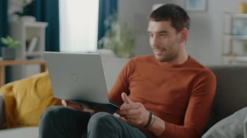 Man Using Laptop Relaxing on Living Room Couch