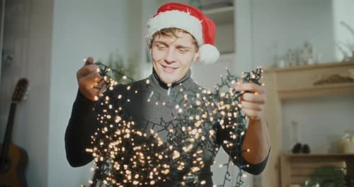 Man Wearing Santa Cap While Sorting Glowing Lights