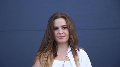 Portrait of a young cheerful Caucasian girl wearing a white shirt. Close-up