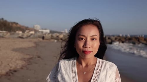 Mulher asiática grávida curtindo uma caminhada na praia