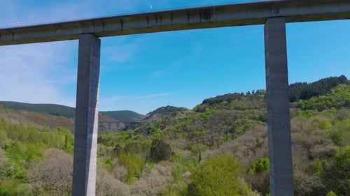 Road Bridge Over The Mountain Valley In Becerrea, Lugo, Spain. - aerial shot