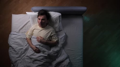 Worried Man Lying Awake at Night in Bed