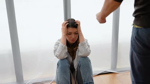 Distressed Woman with Angry Man in Indoor Conflict