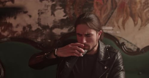 Man Drinking From Glass on Couch Indoors