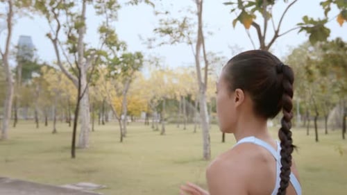 Young fitness woman in sportswear jogging in city park