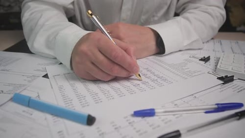 Hands Circuling Numbers on Printed Report