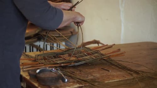 Woman Weaving Twigs and Reeds into a Basket