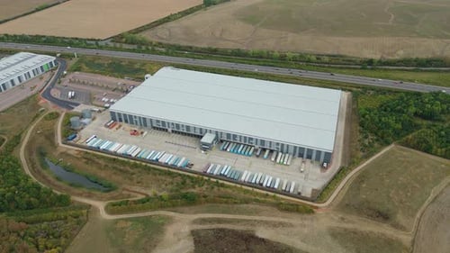 Aerial view of large warehouse near road, United Kingdom.
