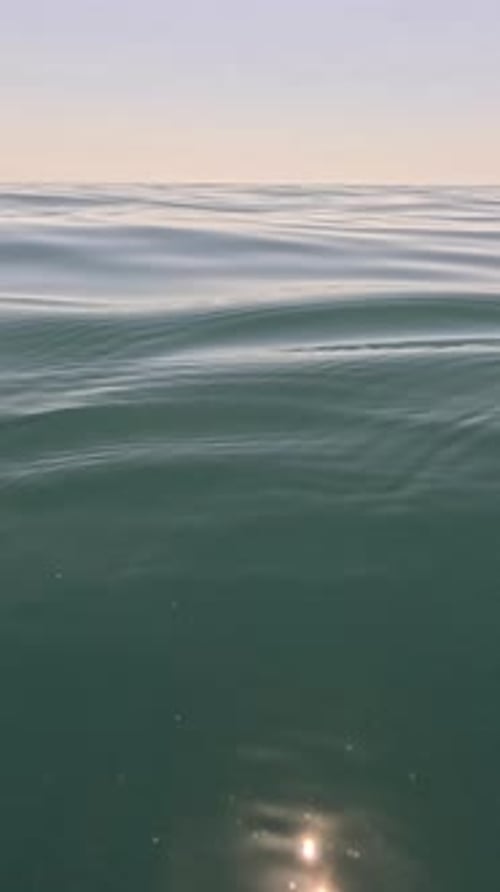 Water Waves Ocean Surface with Gentle Ripples and Shimmering Sunlight at Sunset Vertical Video