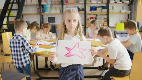 Children Drawing Together in a Bright Classroom
