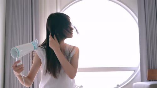 Woman Dries Hair With Hair Dryer at Home