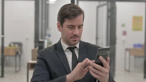 Man in Suit Using Cell Phone in Office
