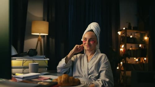 Woman in robe using computer at night at home