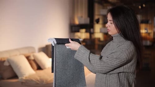 Woman Inspecting Fabric Samples Inside Showroom