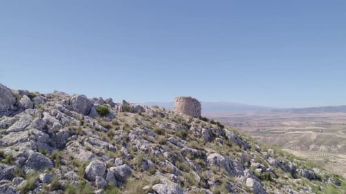 Medieval watchtower. Ruins of a medieval watchtower on a mountain cliff. Aerial tracking shot. Pedro