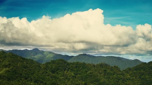 Blue Sky Majesty: Capturing the Dynamic White Clouds on the Mountain.