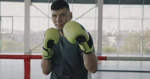 Slow Motion Portrait of Young Boxer Champion Standing in Gym in Ready for Fight Position with Gloves