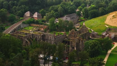 Tourists Enjoy a Sunny Day a Villers La Ville Abbey Historic Ruins Set Against a Backdrop of Lush