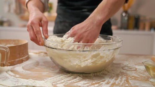 Person Kneading Dough in a Clear Bowl
