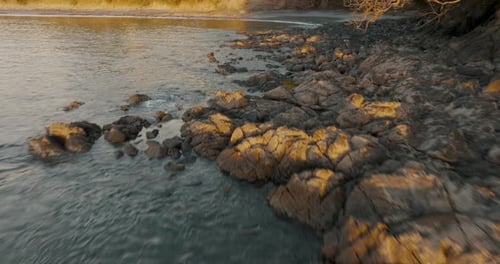 Drone Flying On Rocky Shoreline Of Tropical Beach On Sunset. Aerial Drone Shot