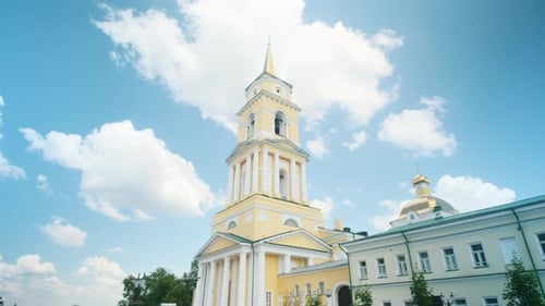 Low angle view of yellow Cathedral building on a blue cloudy summer sky background