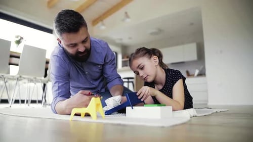 Father and Daughter Playing with Toy at Home