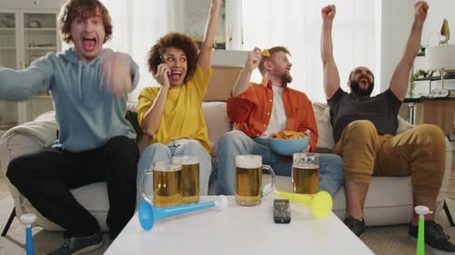 Friends Cheering and Celebrating on Living Room Couch