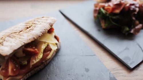 Köstlicher Lachs-Panini und Prosciutto-Salat auf Steinplatten in einem Restaurant