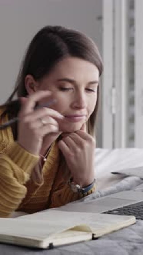 Woman Writing in Notebook While Lying on Bed