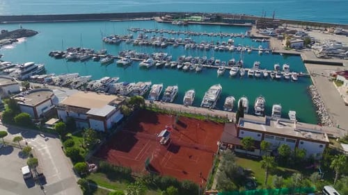 Aerial Video Aerial View of a Tennis Club and Marina With White Yachts and Crystal Blue Waters