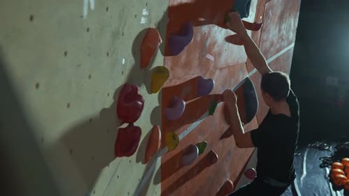 A Professional Climber Trains at a Climbing Wall Practices Rock Climbing