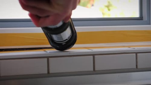 Caulking Gun Applying Sealant to Window Frame