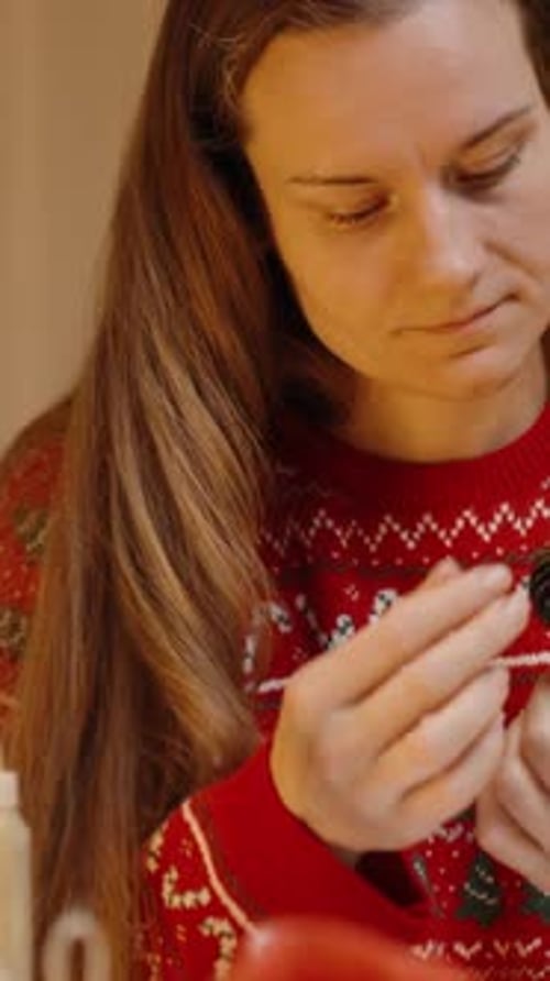 Woman Holding Holiday Ornament Indoors at Christmas