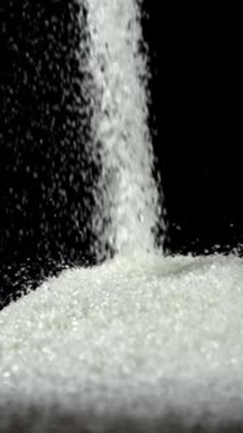White Sugar Falls on the Table in a Heap Filmed on a Highspeed Camera at 1000 Fps
