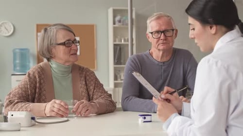 Doctor Talking to Senior Couple in Office