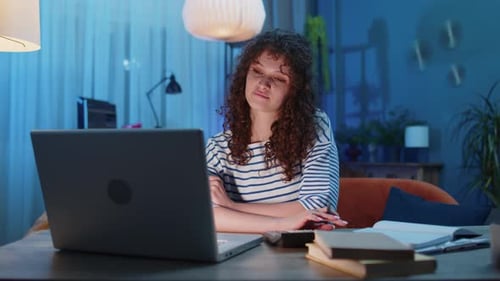 Young Woman Works at Laptop at Home at Night