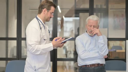 Doctor Consults with Concerned Senior Patient in Hospital