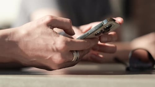 Close Up of Hands Using Cell Phone