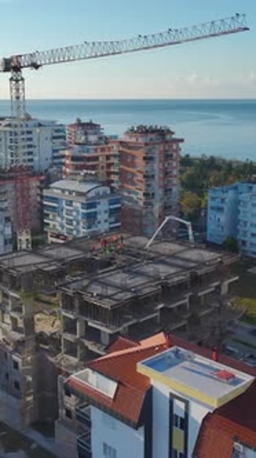 Vídeo vertical de trabajadores de la construcción que preparan pisos con andamios y herramientas capturados verticalmente