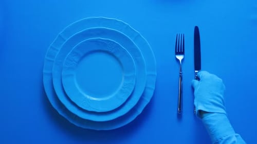 Overhead Shot of Plates and Utensils on Blue Surface