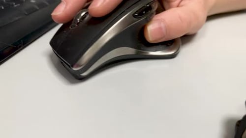 Male hand uses a computer mouse in an office in close-up