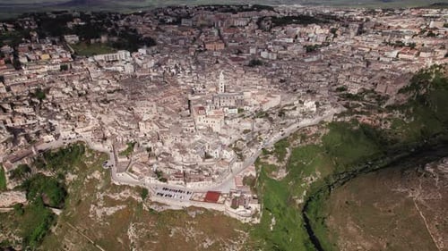 Aerial orbit view of Matera italian ancient city on top of ravine on a sunny day