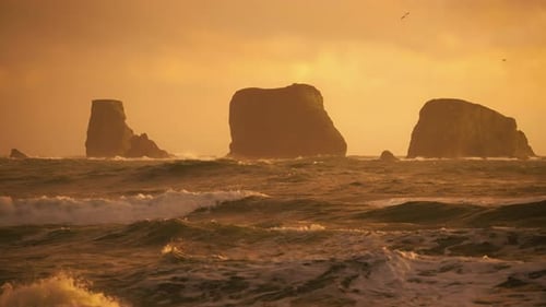Towering Rocks Over Ocean With Rough Waves During Sunset. Slow Motion