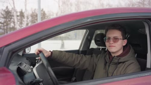 Young Adult Sits in Car During Winter