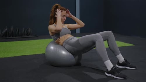Woman with a Beautiful Physique Plays Fitness in the Gym
